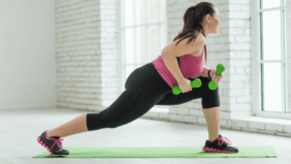 The girl performs an exercise with weights